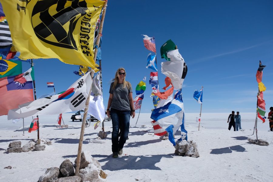Paulette Perhach stands in the snow amidst waving flags at basecamp
