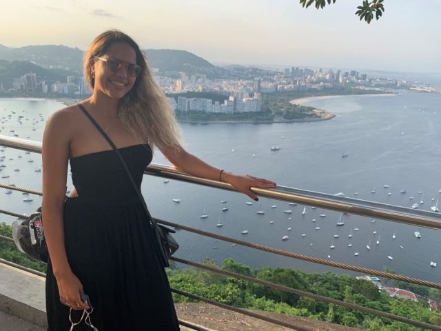 Milagros Rojas standing in front of the view from Morro de Urca over Rio de Janeiro