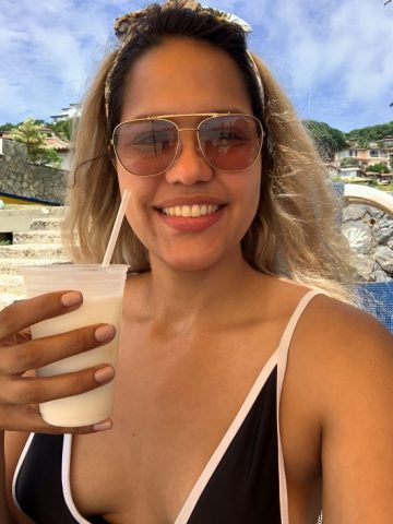 Milagros Rojas taking a selfie with a pina colada in hand
