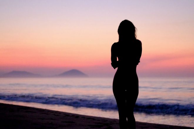 Silhouette of a woman with a sunset behind - solo woman traveling