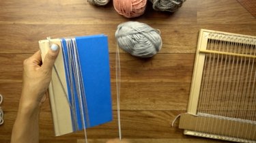 Cutting fringe for an easy DIY woven wall hanging.