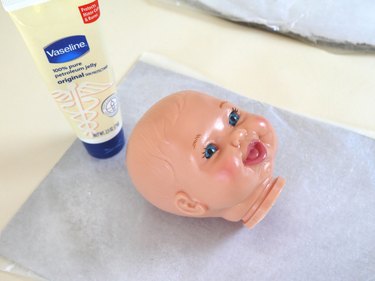 Doll head covered in petroleum jelly.