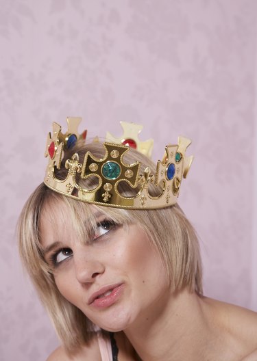 Young woman wearing crown, looking up, close-up