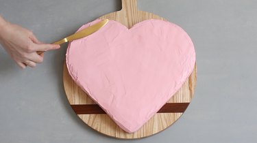 Frosting heart cake with pink icing