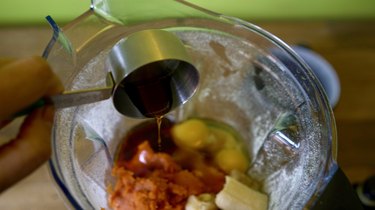 Adding ingredients into blender for pumpkin oat flour muffins