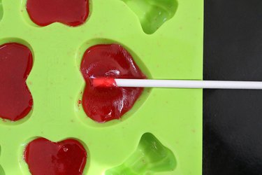 Add lollipop sticks to melted candy