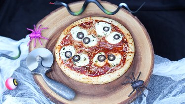 Eyeball pizza served on wood platter