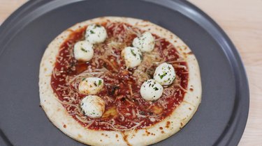 Pairs of mozzarella balls placed on pizza