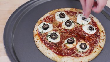 Placing black olive slices on mozzarella balls