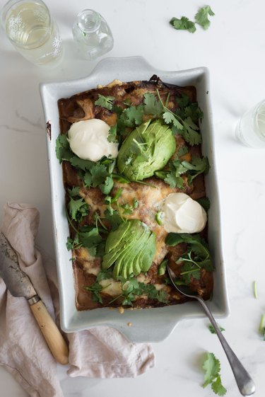 Decorate the enchilada tray bake with your choice of toppings.