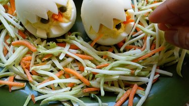 Arranging broccoli carrot slaw into a "nest" for deviled egg Easter chicks.
