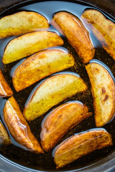 Pan frying the potato wedges in oil