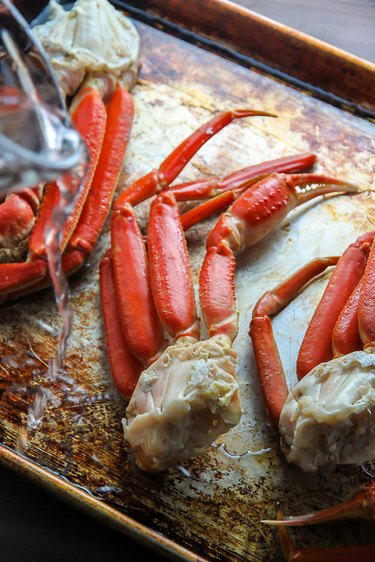 Place crab legs on a baking pan and pour water in.