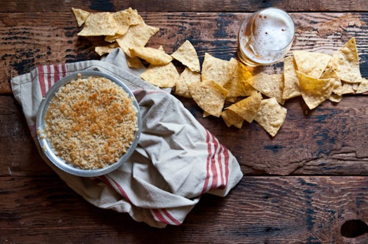 Jalapeno popper beer cheese dip served with chips and a beer.